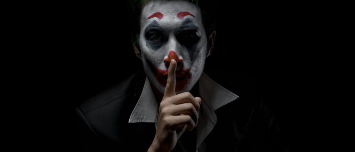 Ein Mann mit Joker-Makeup vor einem dunklen Hintergrund