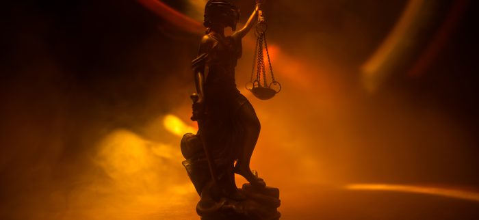 Die Statue der Gerechtigkeit vor dem Hintergrund eines farbigen Nebels