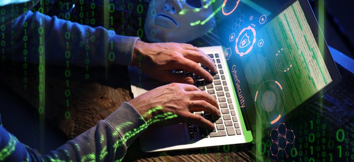 Hacker mit Computer in einem dunklen Raum