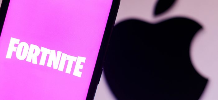Das Fortnite-Logo auf einem Smartphone mit dem Apple-Logo im Hintergrund