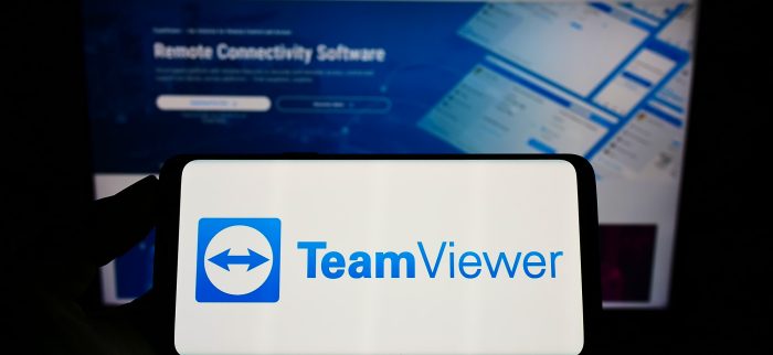 TeamViewer-Logo auf Handybildschirm mit Webseite im Hintergrund