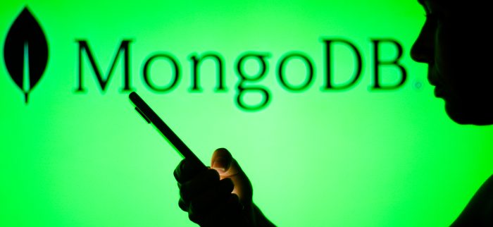 Das MongoDB-Logo ist im Hintergrund einer Silhouette einer Frau zu sehen, die ein Mobiltelefon hält