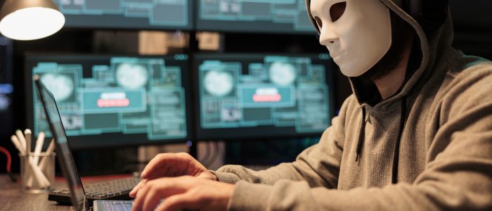 Ein Hacker mit Maske tippt auf einem Keyboard (Symbolbild)