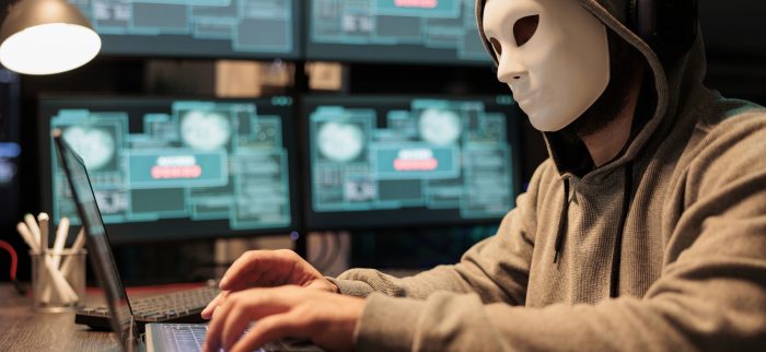 Ein Hacker mit Maske tippt auf einem Keyboard (Symbolbild)