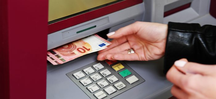 Eine Frau hebt Geld von einem Bankautomaten ab