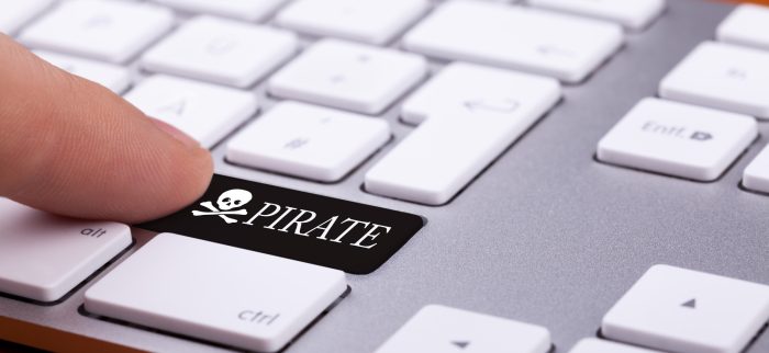 Ein Finger drückt eine schwarze Piratentaste auf einer Tastatur