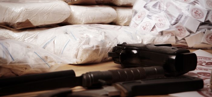 Päckchen mit Dutzenden von Drogen und Rohopium liegen neben Waffen auf einem Tisch