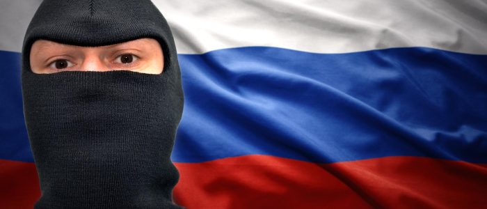 Mann mit Maske auf einem Hintergrund mit russischer Flagge