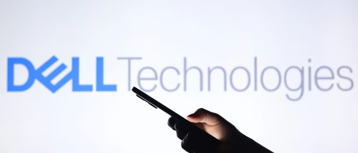 Das Dell-Logo im Hintergrund mit einer Silhouette, die ein Smartphone in der Hand hält