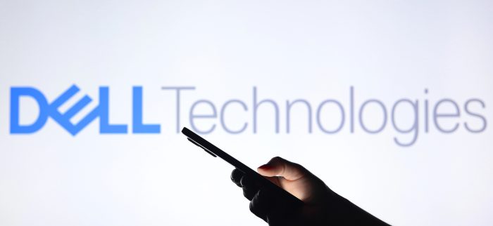 Das Dell-Logo im Hintergrund mit einer Silhouette, die ein Smartphone in der Hand hält