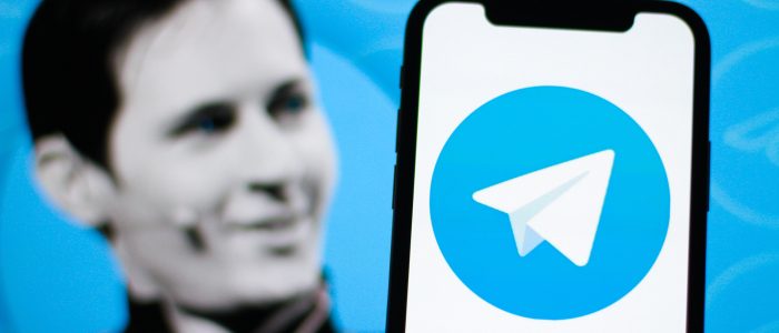 Das Logo von Telegram auf einem Smartphone. Im Hintergrund der Gründer von Telegram. Pavel Durov