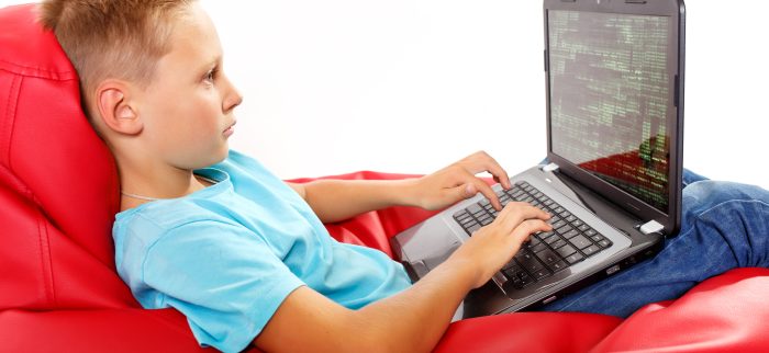 Ein Junge sitzt an einem Laptop