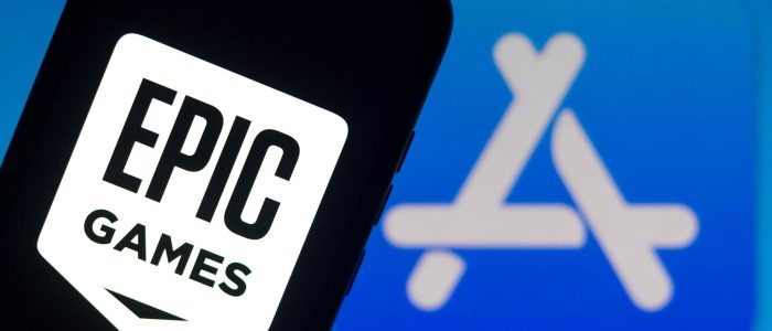 Smartphone mit Epic Games Logo und Apple App-Store Symbol im Hintergrund