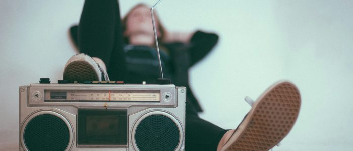Eine Frau liegt auf einem Bett in der Nähe von einem grauen Radio.