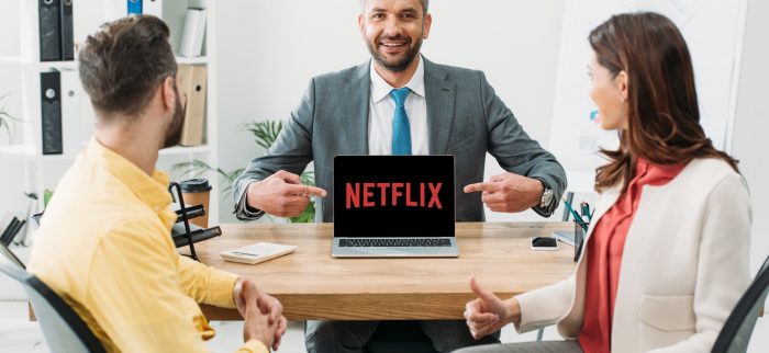 Geschäftsmann zeigt auf Notebook mit Netflix-Logo