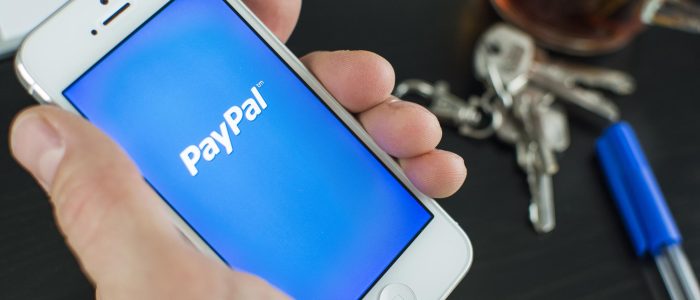 Smartphone mit PayPal Logo, im Hintergrund ein Schlüssel