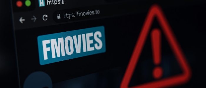 Ein Computerbildschirm mit einer geöffneten FMovies-Seite, im Hintergrund erscheint eine Malware-Warnung – ein Symbolbild, das die Gefahr durch Infostealer bei illegalen Streaming-Seiten veranschaulicht.