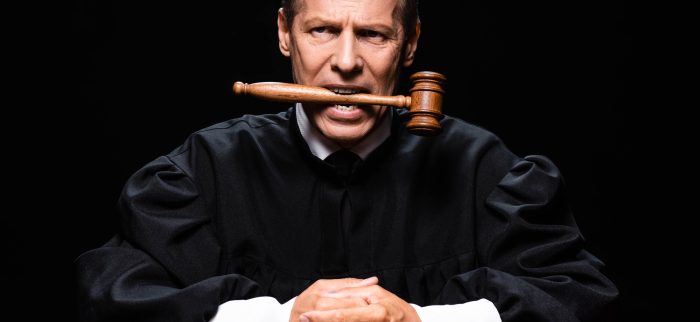 Ein Richter mit seinem Hammer im Mund
