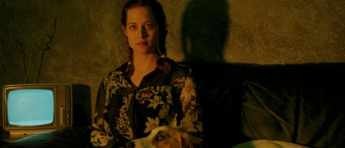 Serien kostenlos streamen, Frau sitzt auf einer Couch mit einem Hund.