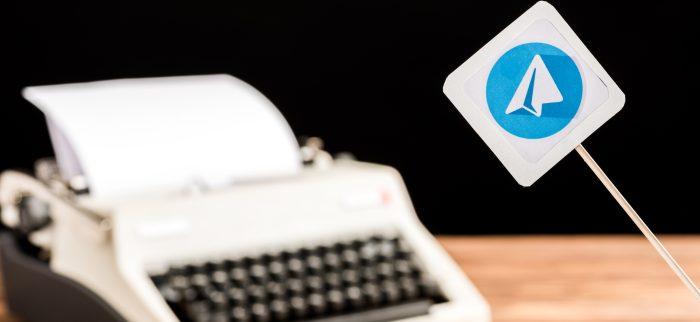 Schild mit Telegram Symbol, im Hintergrund eine Schreibmaschine