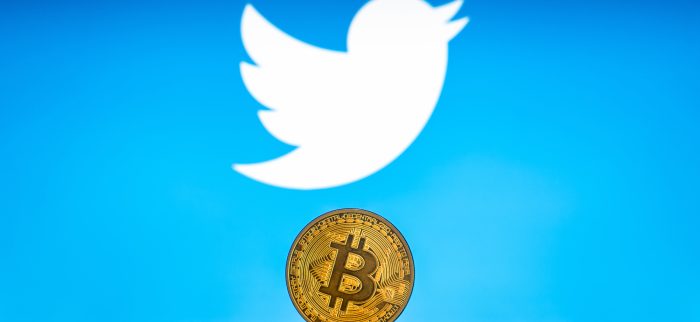 Ein Stapel Bitcoin-Münzen mit Twitter-Logo im Hintergrund