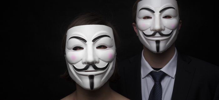 Zwei maskierte Menschen, die auch im Internet anonym bleiben (Symbolbild)
