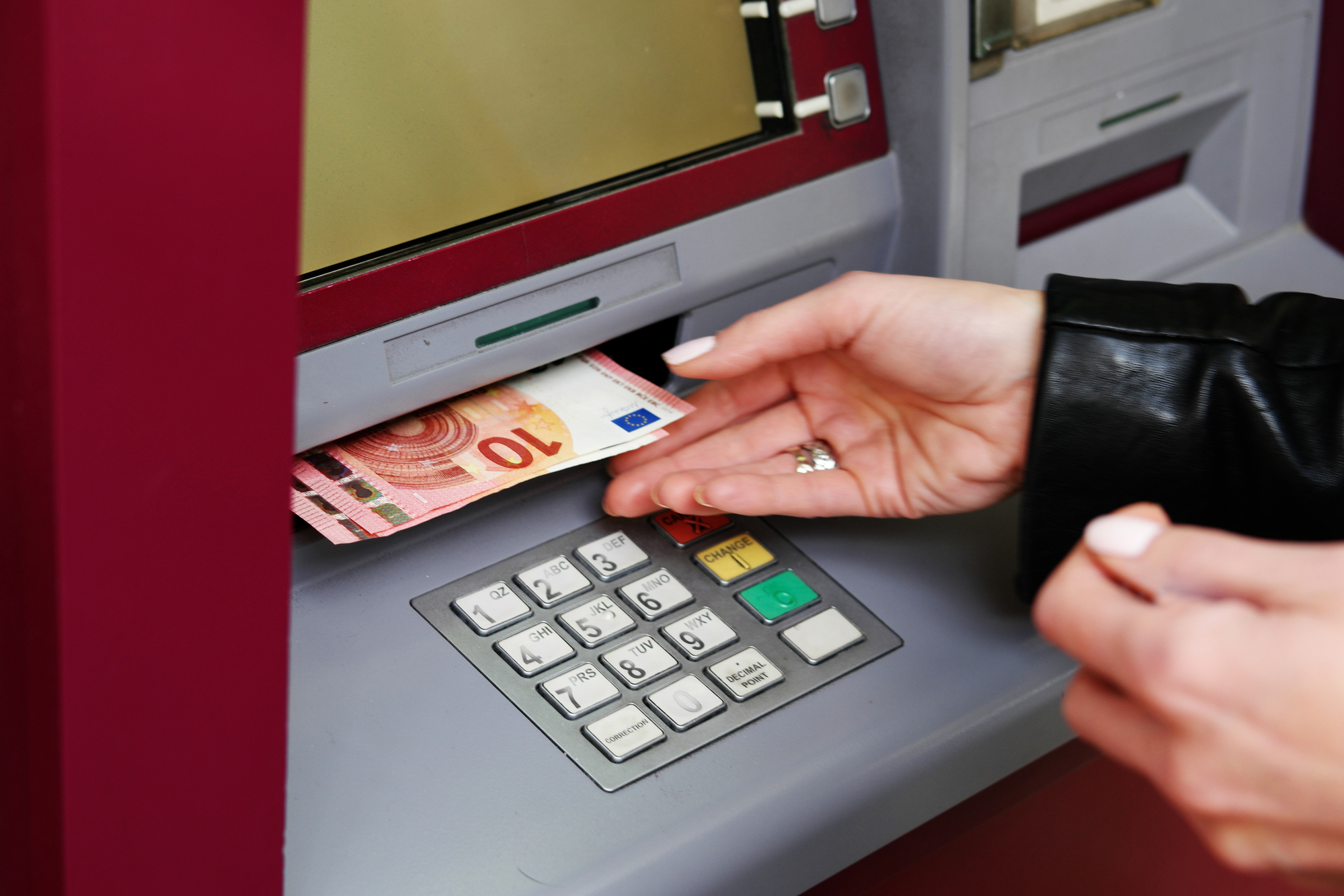 Eine Frau hebt Geld von einem Bankautomaten ab