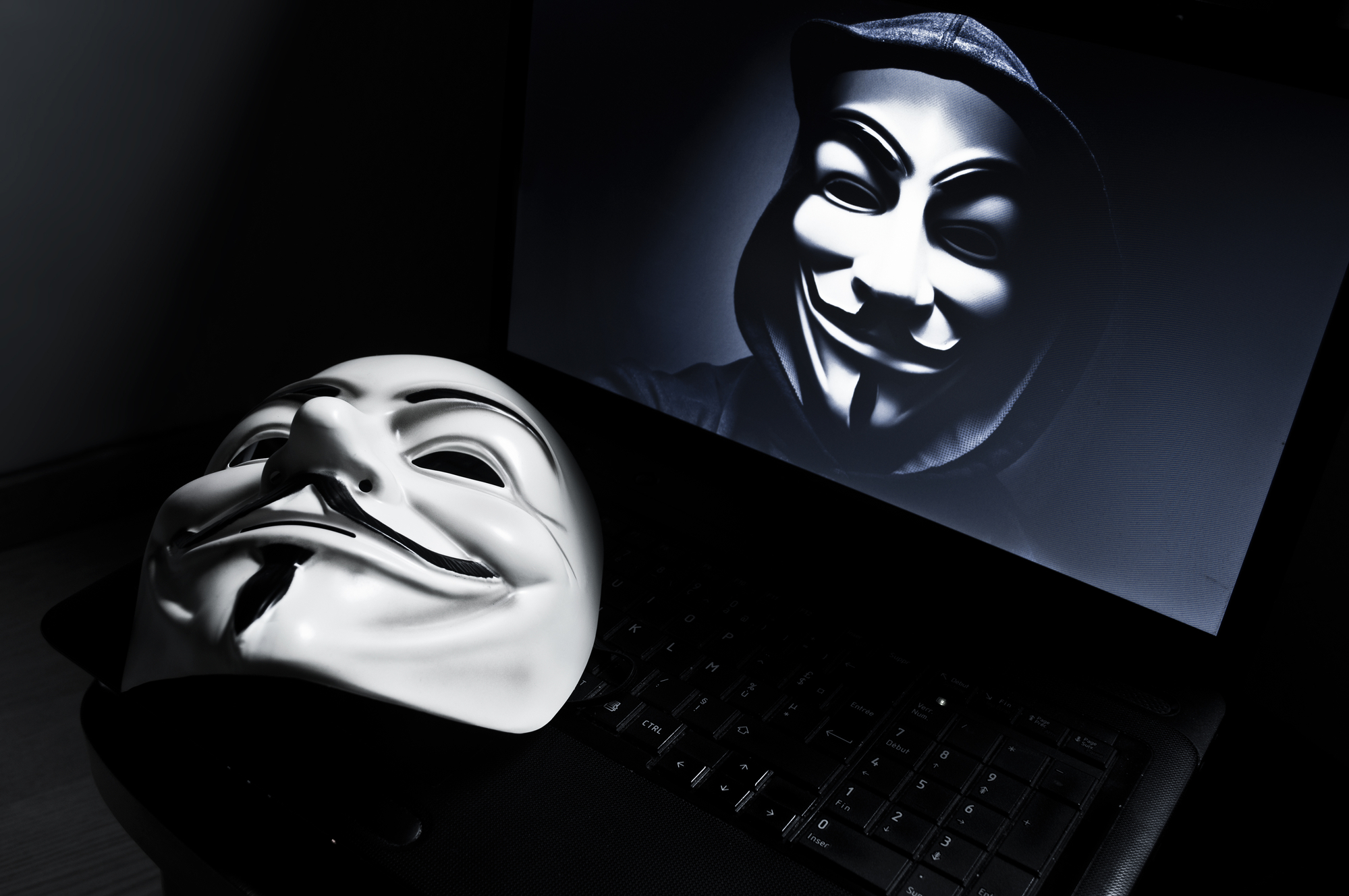 Eine Vendetta-Maske auf einem Laptop mit einem Anonymous-Mitglied auf dem Bildschirm