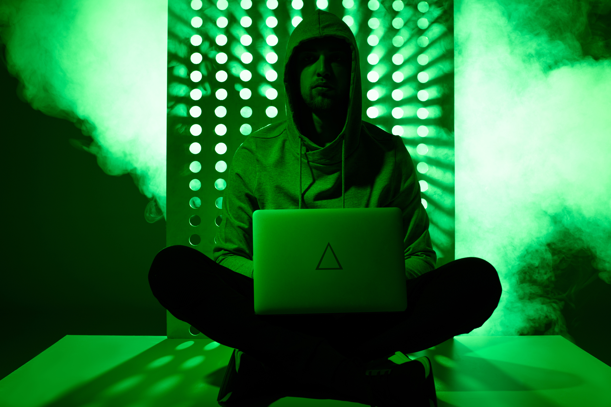 Getöntes Bild von einem Hacker im Kapuzenpulli mit Laptop