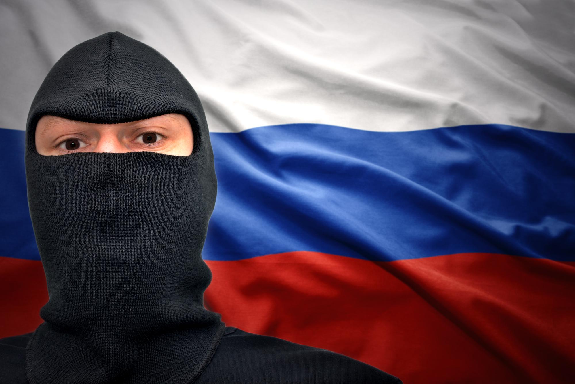 Mann mit Maske auf einem Hintergrund mit russischer Flagge