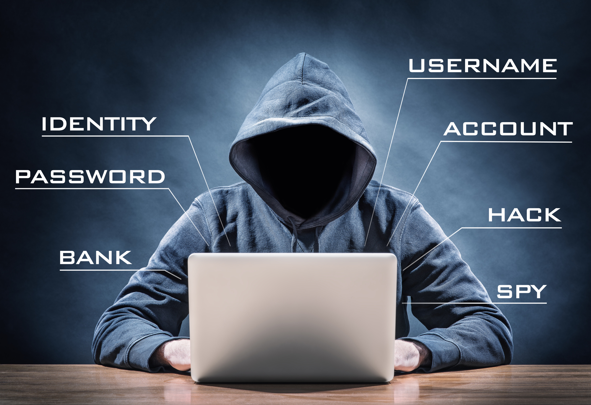 Hacker mit Kapuze vor Laptop (Symbolbild für Passwortsicherheit)