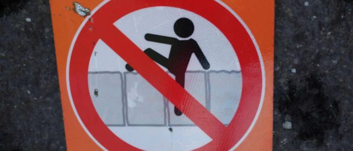 Paywalls, Schild aus Irland, auf dem ein Männchen versucht einen Zaun zu überwinden.