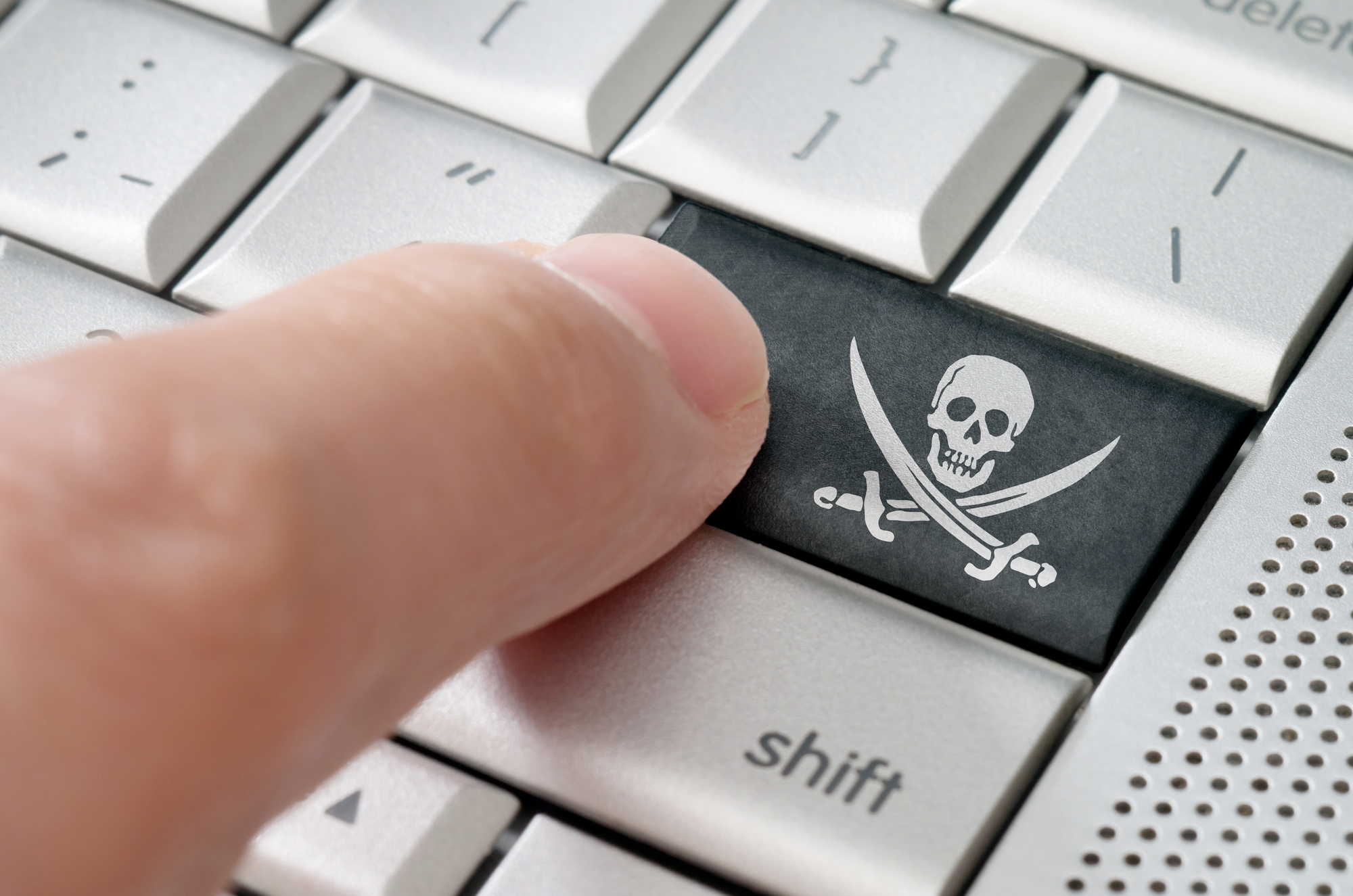 Raubkopierer drückt eine Piratensymbol-Eingabetaste auf einer Laptoptastatur